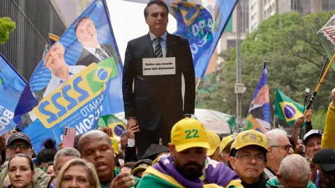 Manifestantes sobem boneco inflável de Donald Trump durante ato do 7 de setembro na Avenida Paulista.